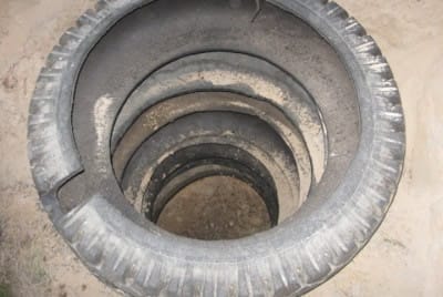 Септик из покрышек: выпиливаем отверстие для канализационной трубы