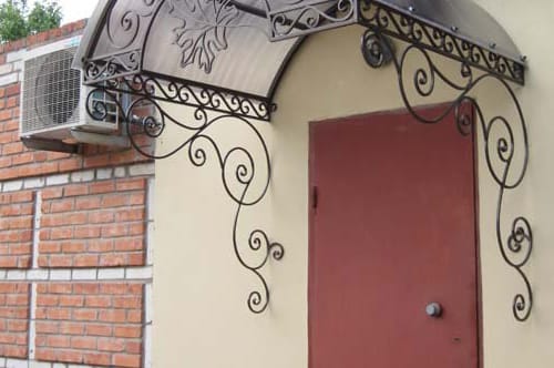 Козырек над крыльцом украшенный чугунной ковкой
