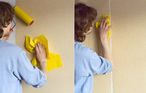 Места стыковки обоев прокатывают валиком, а излишки убирают тряпкой