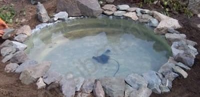 Начинаем обкладывать наш пруд камнем