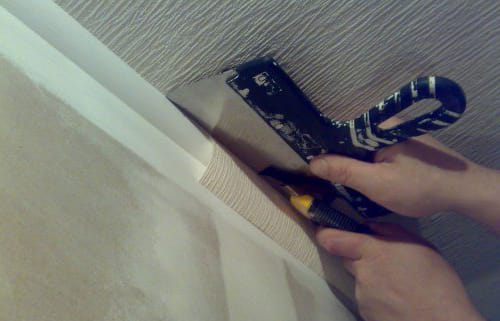 Обрезаем обои острым ножом по шпателю