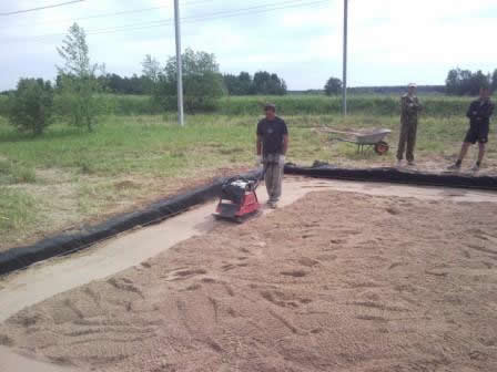 Площадку под фундамент засыпают песком и трамбуют