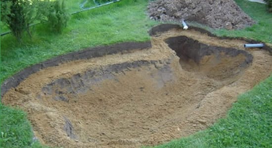 Подсыпаем яму песком и подводим трубы к насосу