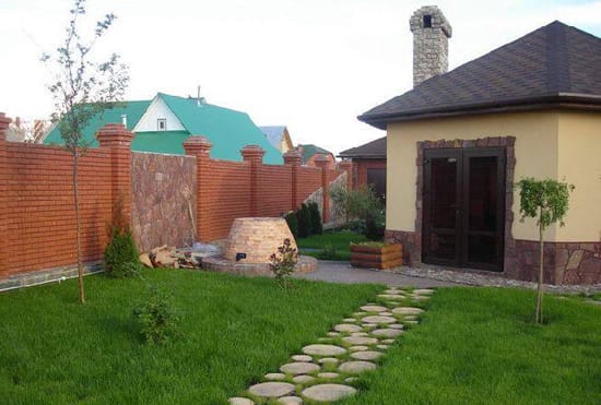 Посеянный газон между спилами из дерева