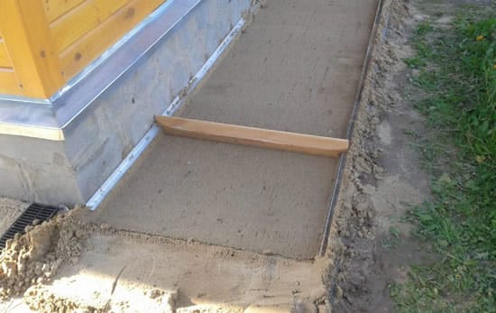 Поверх геотекстиля насыпают слой песка и трамбуют