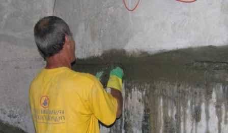 Процесс нанесения раствора на швы фундамента с помощью шпателя