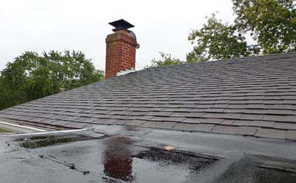 Процесс промазывания крыши битумной мастикой