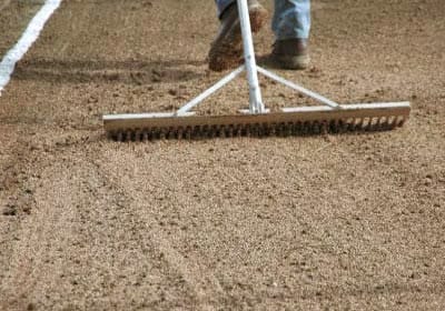 Процесс рыхления почвы граблями