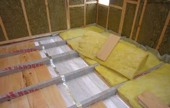 Процесс укладки лагов и минеральной ваты на пол