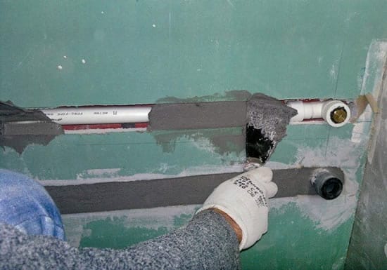 Прячем трубы в стену затем шпаклюем цементом