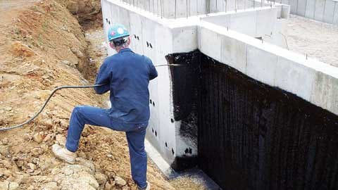 Шаг 4 - процесс нанесения быстросохнущего битумного лака на фундамент