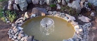 Устанавливаем на дно пруда шланг и делаем небольшой фонтан