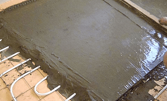 Выравнивание цементной стяжки с помощью правила